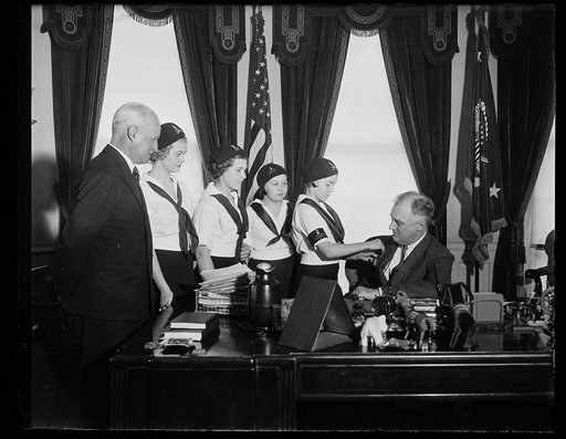 TELL CHIEF OF JUBILEE YEAR. WASHINGTON, D.C. MARCH 17. THIS DELEGATION OF CAMP FIRE GIRLS CALLED UPON PRESIDENT ROOSEVELT, HONORARY PRESIDENT OF THE ORGANIZATION, TO READ TO HIM THE PROCLAMATION OF THE JUBILEE YEAR, AND TO PRESENT HIM WITH THE FIRST JUBILEE BADGE. FROM THE LEFT: LESTER R. SCOTT, NAT