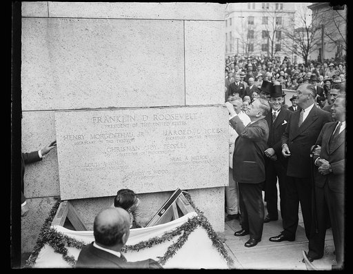 ADMINISTRATOR ICKES LAYS CORNERSTONE OF NEW INTERIOR BUILDING. WASHINGTON, D.C. APRIL 16. ADMINISTRATOR HAROLD ICKES LAYING CORNERSTONE OF THE NEW $12,000,000 INTERIOR BUILDING TODAY WHILE PRESIDENT ROOSEVELT LOOKS ON SMILING. ICKES USED THE SAME TROWEL WITH WHICH GEORGE WASHINGTON EMPLOYED WHEN THE