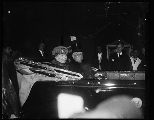 RAIN-SOAKED. WASHINGTON, D.C. JANUARY 20. DRENCHED TO THE SKIN FROM THE HEAVY DOWNPOUR, PRESIDENT AND MRS. ROOSEVELT WERE STILL ABLE TO SMILE AS THEY RETURNED TO THE WHITE HOUSE IN AN OPEN CAR FOLLOWING THE SWEARING-IN CEREMONIES AT THE CAPITOL