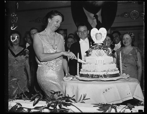 FIRST LADY CUTS PRESIDENT'S BIRTHDAY CAKE. WASHINGTON D.C. JANUARY 30. MRS. ROOSEVELT CUTTING THE PRESIDENT'S BIRTHDAY CAKE AT THE RALEIGH HOTEL TONIGHT. THOUSANDS THRONGED THE HOTELS IN WASHINGTON TONIGHT TO CELEBRATE THE CHIEF EXECUTIVE'S 55TH BIRTHDAY