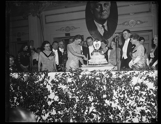 FIRST LADY CUTS PRESIDENT'S BIRTHDAY CAKE. WASHINGTON D.C. JANUARY 30. MRS. ROOSEVELT CUTTING THE PRESIDENT'S BIRTHDAY CAKE AT THE RALEIGH HOTEL TONIGHT. THOUSANDS THRONGED THE HOTELS IN WASHINGTON TONIGHT TO CELEBRATE THE CHIEF EXECUTIVE'S 55TH BIRTHDAY