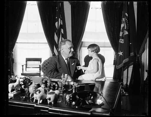 PRESIDENT RECEIVES FIRST BUDDY POPPY. WASHINGTON, D.C. APRIL 6. TODAY WAS HAPPY ONE FOR LITTLE FOUR-YEAR-OLD RUTH JOYCE BRADISH AS SHE PINNED THE FIRST BUDDY POPPY OF 1937 ON PRESIDENT ROOSEVELT AT THE WHITE HOUSE. THE SALE OF BUDDY POPPIES IS CONDUCTED ANNUALLY DURING THE WEEK OF MEMORIAL DAY BY TH