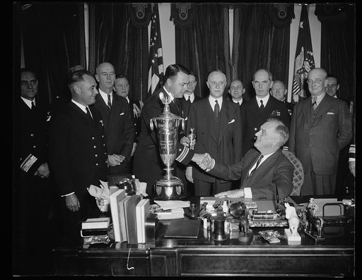 PRESIDENT PRESENTS SCHIFF TROPHY. WASHINGTON, D.C. DECEMBER 14. PRESIDENT ROOSEVELT TODAY PRESENTED THE SCHIFF TROPHY TO COMMANDER ROBERT FULLER, COMMANDING OFFICER OF VP SQUADRON SEVEN OF THE FLEET BASE FORCE AT SAN DIEGO. THE TROPHY IS AWARDED ANNUALLY TO THE NAVAL FLYING UNIT WHICH HAS THE BEST R