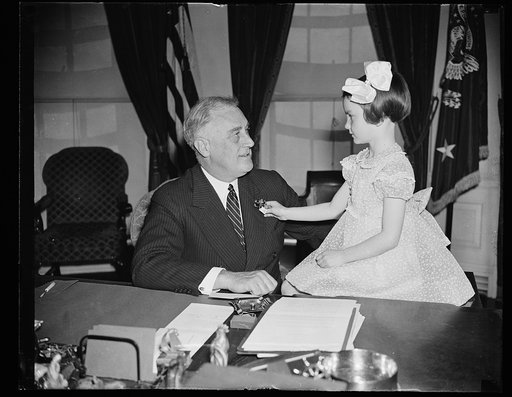 FIRST BUDDY POPPY TO CHIEF EXECUTIVE. WASHINGTON, D.C. APRIL 14. THE FIRST BUDDY POPPY OF THE NATIONAL POPPY SALE FOR 1938 WAS TODAY PRESENTED TO PRESIDENT ROOSEVELT BY SIX-YEAR-OLD JANE COLGAN, DAUGHTER OF A DECEASED EX-SERVICE MAN. THE SALE OF THE BUDDY POPPIES WHICH IS HELD EVERY YEAR DURING THE 