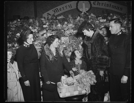 FIRST LADY ASSISTS SALVATION ARMY. WASHINGTON, D.C. DECEMBER 23. AS PART OF HER PROGRAM OF SPREADING CHRISTMAS CHEER, MRS. FRANKLIN D. ROOSEVELT ASSISTED THE SALVATION ARMY IN THE DISTRIBUTION OF XMAS FOOD BASKETS TO THE NEEDY OF WASHINGTON. IN THE PICTURE, L TO R: MRS. CHARLES H. DODD; MRS. FANNIE 