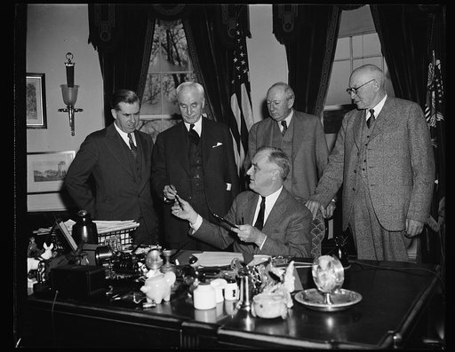PRESIDENT PRESENTS TO SECRETARY HULL PEN USED IN SIGNING BILL TO EXTEND TRADE PROGRAM. WASHINGTON, D.C. APRIL 12. PRESIDENT ROOSEVELT PRESENTING TO SECRETARY OF STATE CORDELL HULL ONE OF THE PENS HE USED IN THE SIGNING TODAY THE BILL EXTENDING FOR THREE YEARS THE POWER OF THE UNITED STATES TO NEGOTI