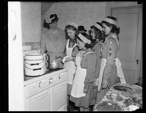 GIRL SCOUTS PREPARE LUNCHEON UNDER WATCHFUL EYES OF MRS. ROOSEVELT. WASHINGTON, D.C. APRIL 30. ARRIVING EARLY AT THE GIRL SCOUTS LITTLE HOUSE WHERE SHE WAS HONOR GUEST AT A LUNCHEON TODAY, MRS. ROOSEVELT WATCHED THE YOUNGSTERS PREPARE THE FOOD THEY LATER SERVED AT THE MEAL. THE FIRST LADY'S VISIT HI