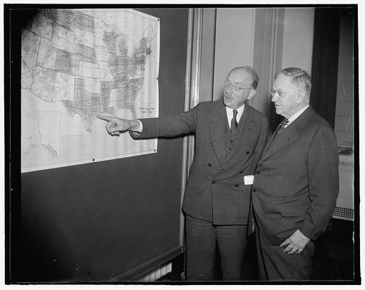 Interior Secretary and his choice for federal housing post. Washington, D.C., Sept. 20. Following a meeting today with housing experts from all parts of the country, Secretary of Interior Harold Ickes views a a map showing the location of the many low-cost housing projects now under way. Dr. Howard 