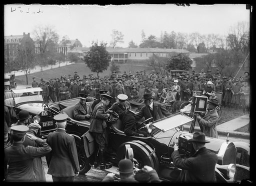 Military group gathered near automobile with officers