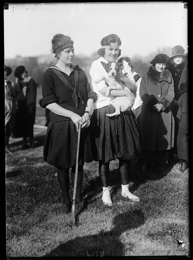Women with field hockey stick and dog