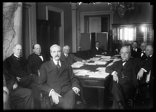 Group at table; includes Frank Kellogg, 4th from left