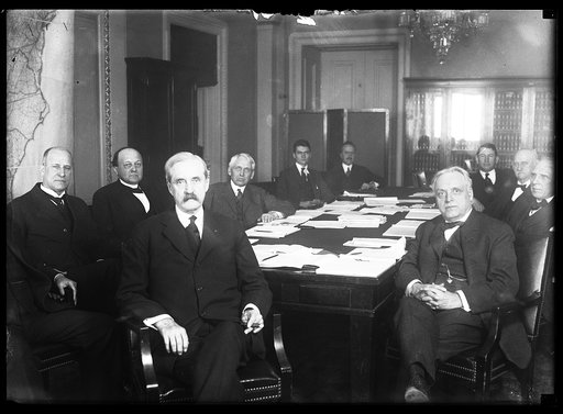 Group at table; includes Frank Kellogg, 4th from left