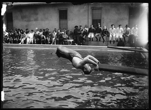 Man without legs going off board into swimming pool