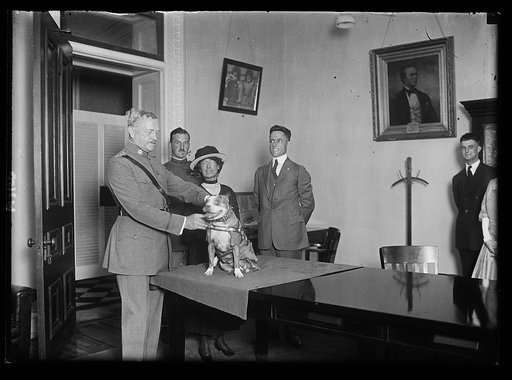John J. Pershing holding his dog Sgt. Stubby, as Robert Conroy, wearing suit, stands behind them