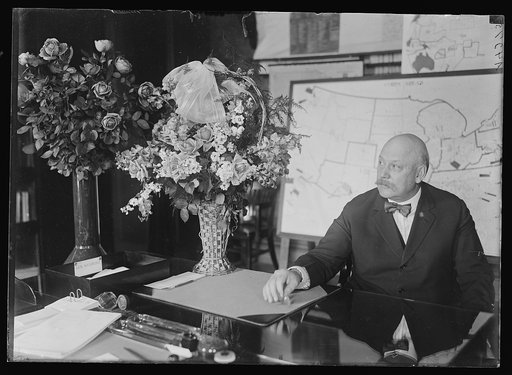 John W. Weeks at desk with flowers