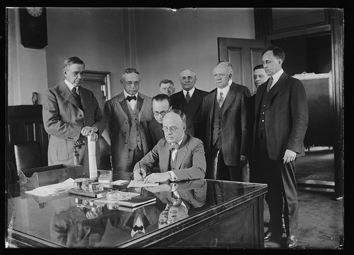 Group at desk; Hubert Work, left