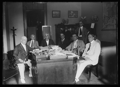 Group at desk; includes Joe Byrns, 2nd from left, and William E. Borah, 3rd from right