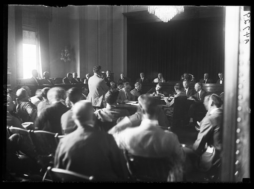 Opening of Dougherty trial. The attempt to impeach Atty. Gen. Harry M. Dougherty, open Sat., Sept. 16, when the case was called for a hearing before House Judiciary Comm. Cong. Keller, Rep. of Minn. shown standing as he opened his charges. Cong. Volstead at rear center of platform. Hearing was postp