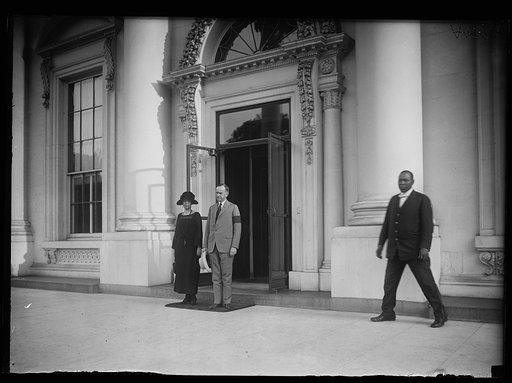 Grace and Calvin Coolidge standing at entrance to White House, Washington, D.C.