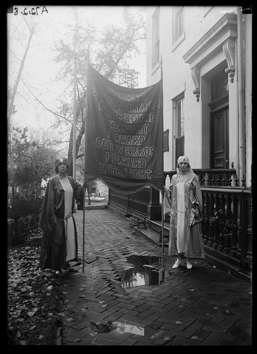 Women with banner: "Forward out of darkness, leave behind the night; forward out of error, forward into light"