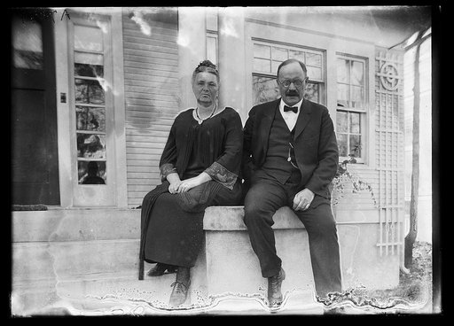 Magnus Johnson with wife? on front porch of house