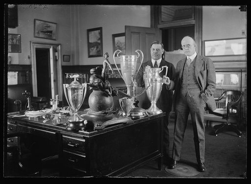 Men with trophy cups on desk