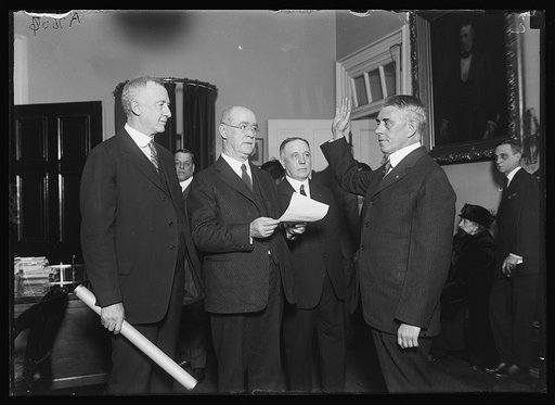 Rear Admiral F.C. Billard, right, being sworn in as new Commandant of U.S. Coast Guard, succeeding Adm. Reynolds, retired