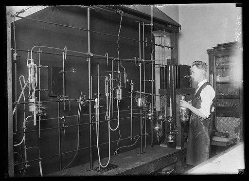 Dr. D.C. Bardwell, of the Research Lab. of the U.S. Bureau of Mines, collecting gaseous radium emanation. The radium is in the little safe at the right. Collections are made at intervals of from 4 to 10 days. The gas is drawn off under vacuum and purified by a liquid air refrigeration. The purified 