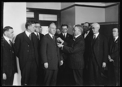 Gen. Lloyd M. Brett, right, Nat'l Comdr. Veterans of Foreign Wars, pinning the first poppy emblematic of the Amer. soldiers disabled in the World War, on Gen. Frank T. Hines, Direct. of the Veterans Bur., others in the group included Gen. L. Brett's staff, the Asst. Dirct. of the Bur.