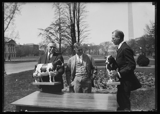 Henry C. Wallace, center, with unidentified and cow figures; Washington Monument in background. Washington, D.C.