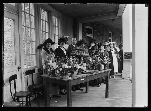 Looking at some of the flower baskets, trays, and lamps made by wounded soldiers at Mr. Alton Hospital, Wash., during the 4th Annual garden party tendered the disabled veterans by the Geo. Baldwin McCoy Unit of the Amer. Women's Legion. Left to rt.: Mrs. Robt. Coe, Mrs. Frank T. Hines, Gen. Hines, D