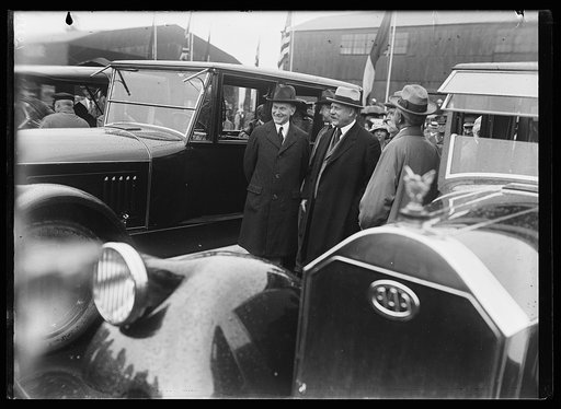 Calvin Coolidge and John W. Weeks and group next to automobiles