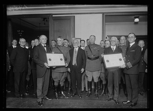 Reverends and chaplains with medals awarded to WWI chaplains on plaques from the Federal Council of Churches of Christ in America; 7th from right: Col. John Thomas Axton, Chief of Chaplains, 1920-1928; and, 2nd from left: Capt. Evan W. Scott, Chief Chaplain of the Navy, 1921-1926
