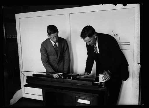 Barrel of a .30 caliber rifle photographed. For the first time, in a motion picture has been made of the entire interior of a .30 caliber rifle barrel. This photograph shows I.C. Gardner, (left) and F.A. Case, of the U.S. Bureau of Standards in Washington, who designed the apparatus. This novel came