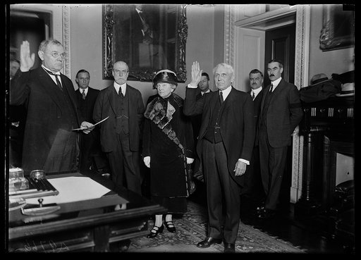 Frank Kellogg swearing in; group includes Charles Evans Hughes, third from left