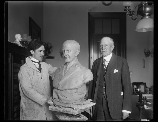 Sculptor working on bust of unidentified