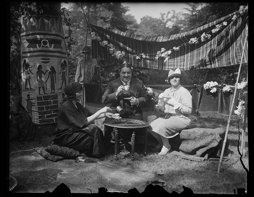 Neighborhood house garden fete. The Egyptian Minister and Mme Smay Pasha, (right) refreshing themselves with coffee at the Egyptian booth served by Mrs. R.W. Imbrie. Mrs. Imbre is the widow of Maj. Imbre who lost his life in Persia several years ago