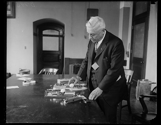 Eggs weighed to determine their grade. W.A. Dalziel, Deputy Sealer of Weights and Measures of Oregon now attending the national conference on weights and measures in Washington, is shown with some of the special scales which have been developed for weighing individual eggs to determine their grade