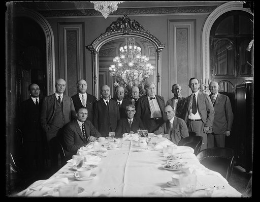 Group at dining table; Walter Johnson, seated at left