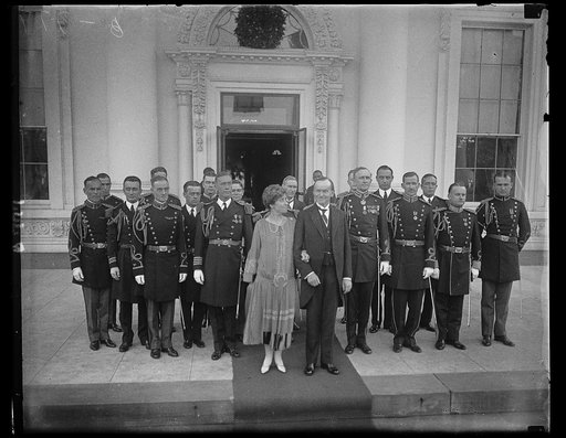 Pres. and Mrs. Coolidge with the military and Naval White House aides of the New Year's Reception. Right back of Pres. is Col. Sherwood Cheney, Chief Military Aide; Commander Wilson Brown, Chief Naval Aide is behind Mrs. Coolidge