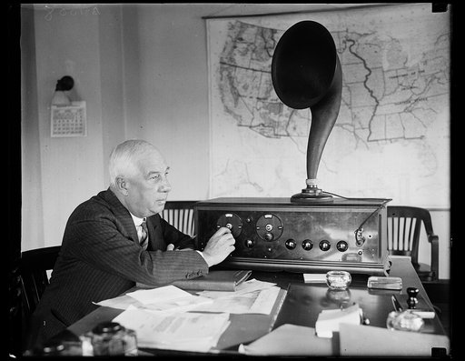 "Boss of the ether" tunes in. Rear Admiral W.H.G. Bullard, chairman of the newly created Federal Radio Board, who recently arrived in Washington from China, "tunes in" on a radio set in his office at the Department of Commerce