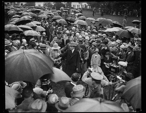 President receives doctors in rain. Braving the wind and rain and against his physician's orders, President Coolidge greeted thousands of doctors at the White House today. The physicians are in Washington attending the annual [...] Convention of the American Medical Association. In this photograph [