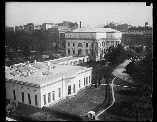 Roof of White House is being removed for a new one. A complete new roof will be on the White House by the time President Coolidge moves in again next September. This photograph, made today, shows the preparations women have made for a temporary roof while the old one is being removed