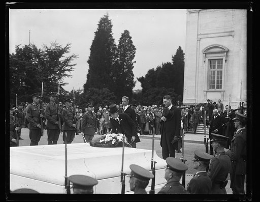 President Coolidge pays homage to Unknown Soldier. President Coolidge placing a wreath on the Tomb of the Unknown Soldier in Arlington National Cemetery today, Memorial Day, in memory of the many brave boys who gave their lives for their country. Near the president is the Secretary of Navy, Curtis D