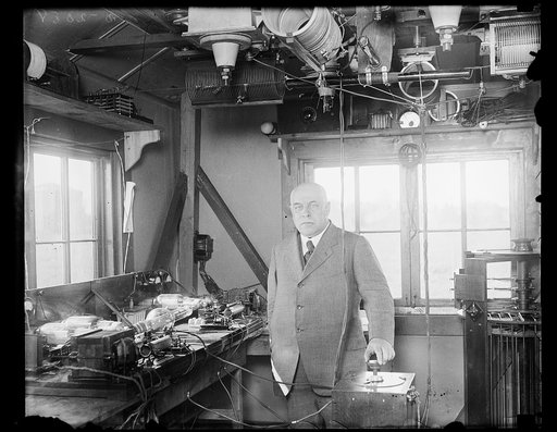 The first radio beacon is inaugerated. An executive photograph showing Dr. George K. Burgess, Director fo the United States Bureau of Standards, and the aircraft radio beacon at College Park, Maryland, designed for guiding airplanes by radio. This is the first radio beacon for use of civil aviation 