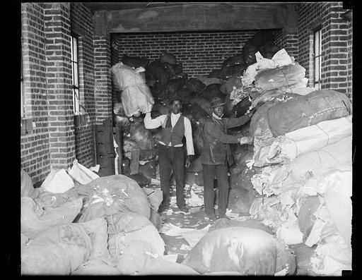 African American men handling large bags of paper