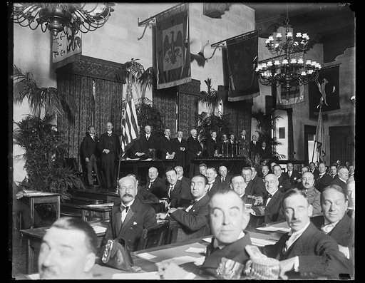 Group on stage; Herbert Hoover at podium