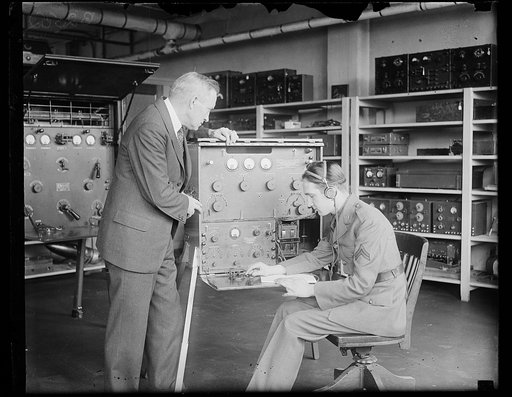 U.S. Chief Signal Officer inspects new radio equipment for talking to Aviators in flight. The new aircraft-radio equipment designed by both the Signal Corps of the War Department permits of both radiotelephone and radiotelegraph communication, sending, receiving, at the same time. The apparatus is u
