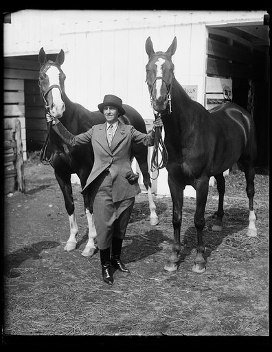 Wife of New York department store magnate captures first and second prizes at Washington Horse Show. Mrs. Bernard Gimbel, wife of the New York department store magnate, and her horses Capt. Doane (left) and welcome with with whom she captured first and second prizes in the Ladies Hunters class at th