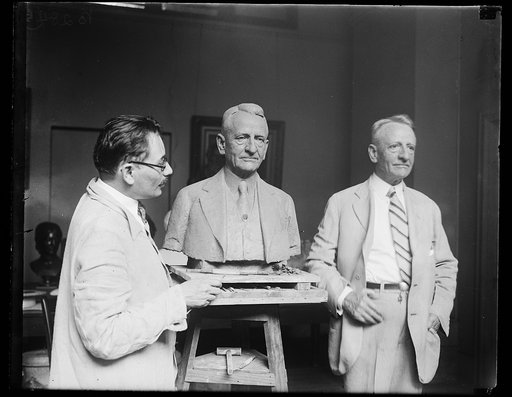 Sculptor sculpting bust of unidentified man
